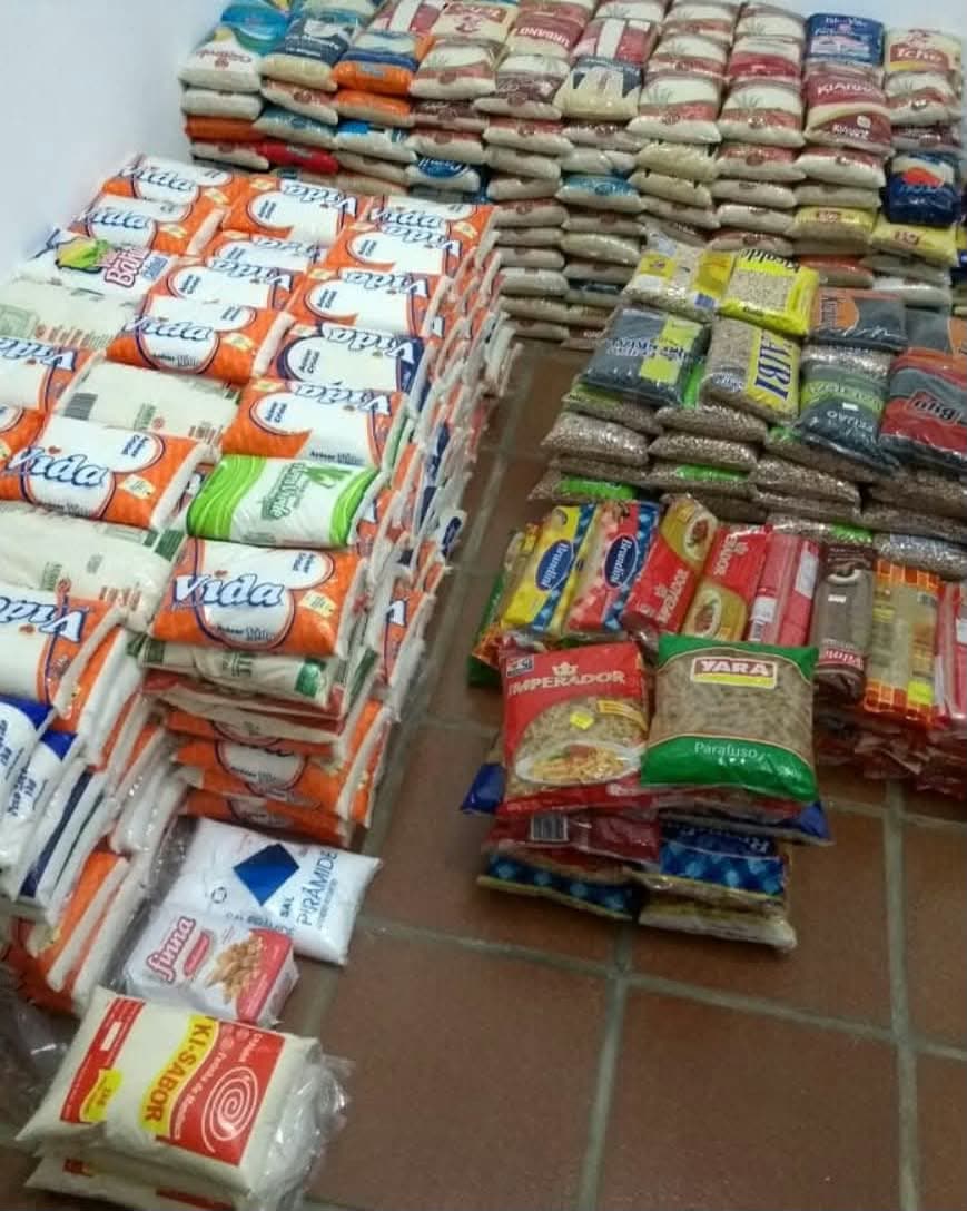 Alimentos não perecíveis arrecadados pelo Arrasta-Pé Solidário, empilhados antes da entrega